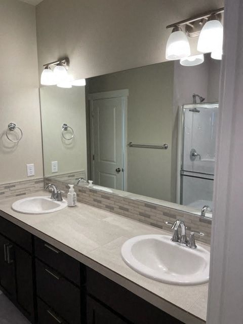 A bathroom with a sink and mirror.