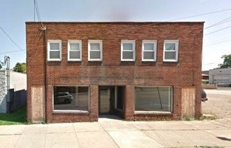 A brick building with a white door and windows.