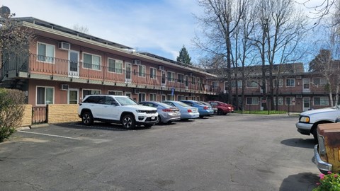 A parking lot with cars and a building in the background.