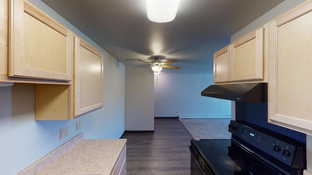 A kitchen with wooden cabinets and a black stove top oven.