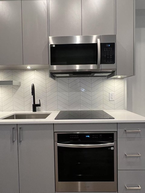 A modern kitchen with a stainless steel oven and microwave.