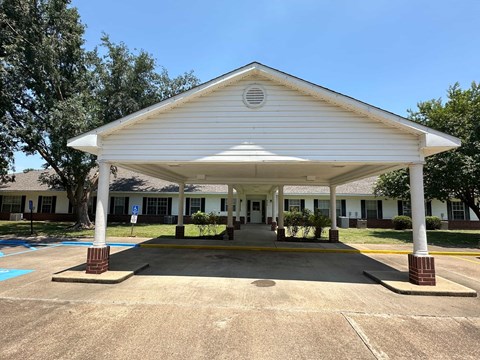 A white covered walkway leads to a building.