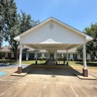 A white covered walkway leads to a building.