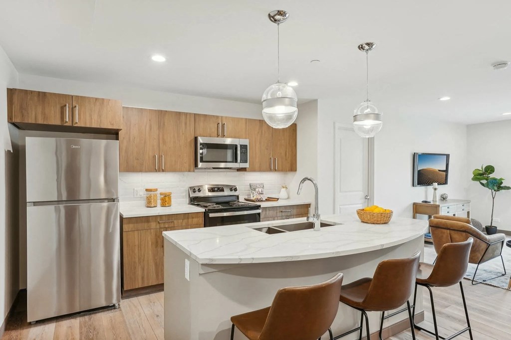 A modern kitchen with a large island and stainless steel appliances.