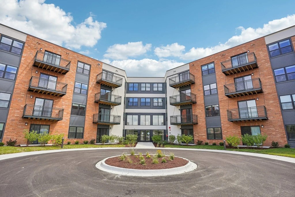 A roundabout leads to a building with a white and black facade.