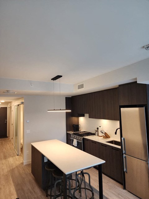 A kitchen with a white table and a refrigerator.