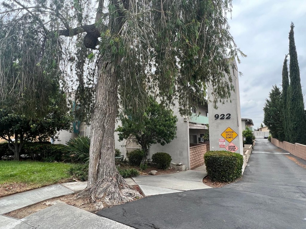 A tree is in front of a building with the number 922 on it.