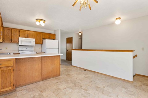 A kitchen with wooden cabinets and a white fridge.