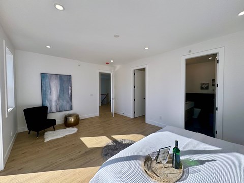 A modern living room with a black chair and a painting on the wall.