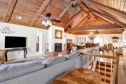 A living room with a grey couch and a wooden ceiling.