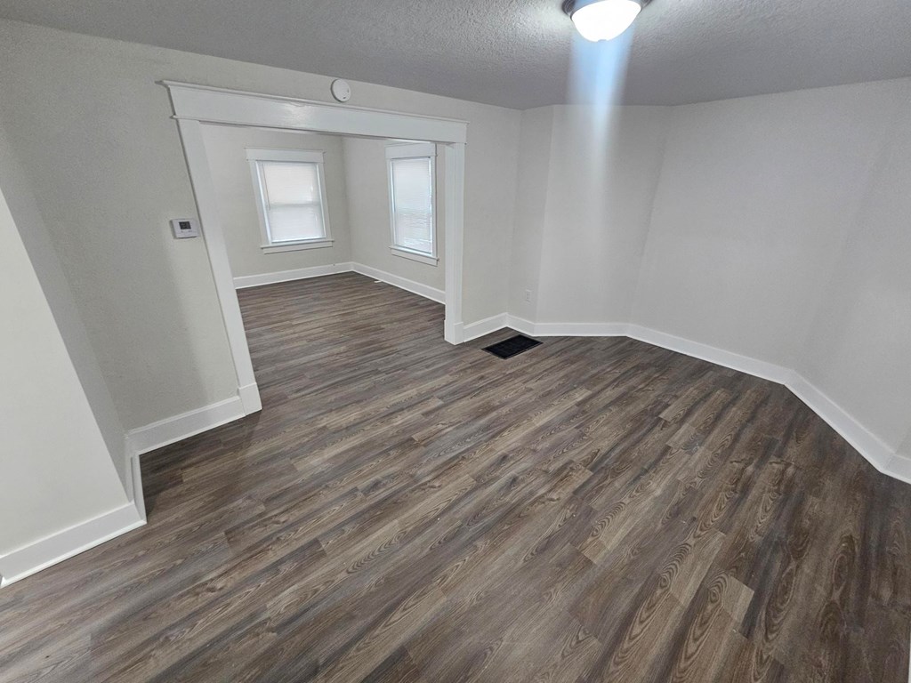 A room with wooden flooring and white walls.