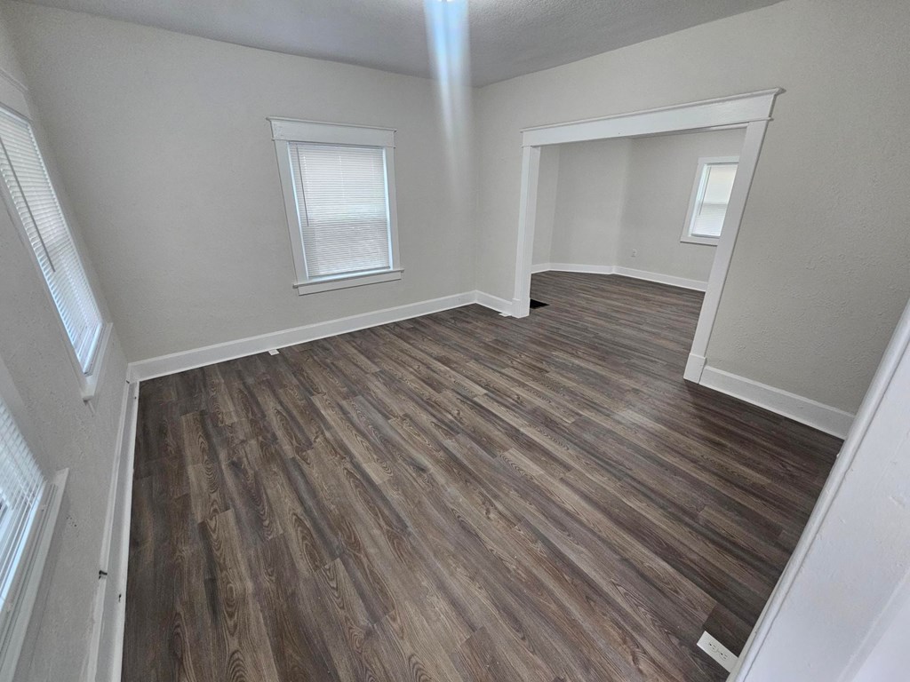 A room with wooden flooring and white walls.
