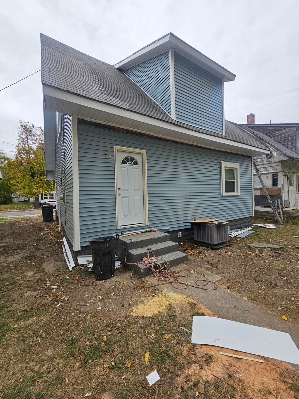 A blue house with a white door and a window.