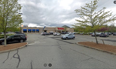 A parking lot with cars and a Walmart store in the background.