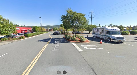 A street view with a white truck parked on the side of the road.