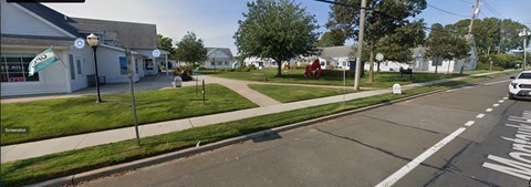 A street view with a car parked on the side of the road.