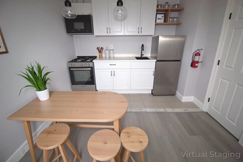 A kitchen with a table and stools in the foreground.