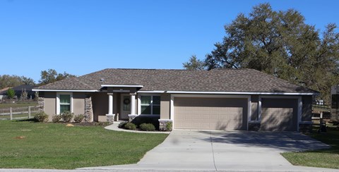 A house with a brown roof and a grey garage door.