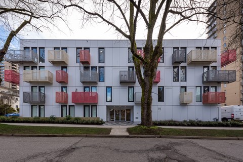 A white building with red and black balconies.