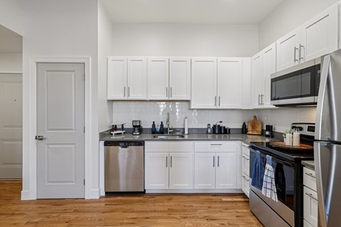 A kitchen with white cabinets and appliances.