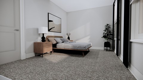 A bedroom with a bed, nightstand, lamp, and plant.