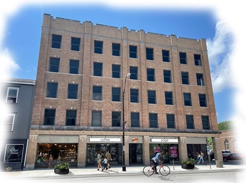 A large brick building with a coffee shop and yoga studio on the ground floor.