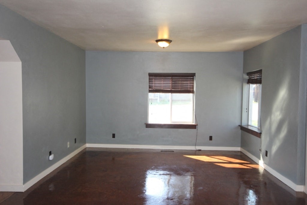 A room with a window and a wooden floor.