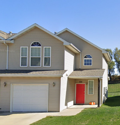 A house with a red door and a white garage door.
