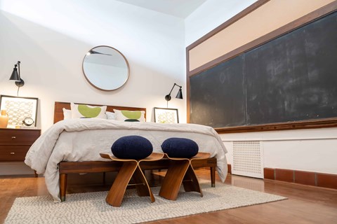 A bedroom with a large bed and two blue pillows.