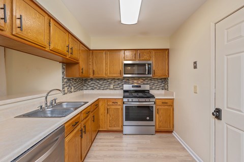 A kitchen with wooden cabinets and stainless steel appliances.