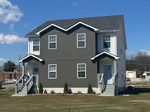 A grey house with white trim and a grey roof.