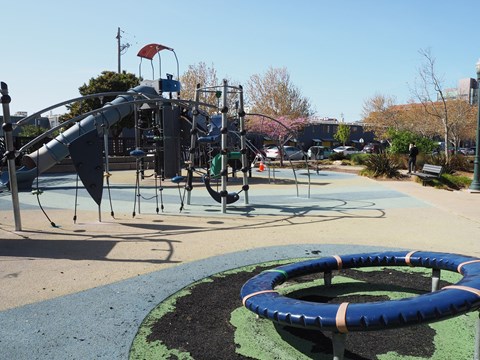 A playground with a slide, swings, and a roundabout.