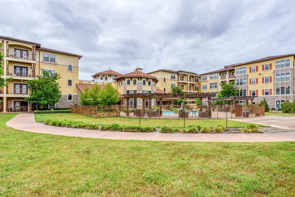Apartment complex with a grassy area in front.
