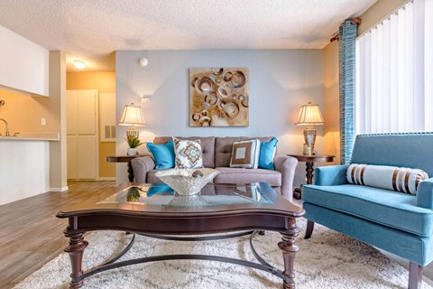 A living room with a blue couch and a coffee table.