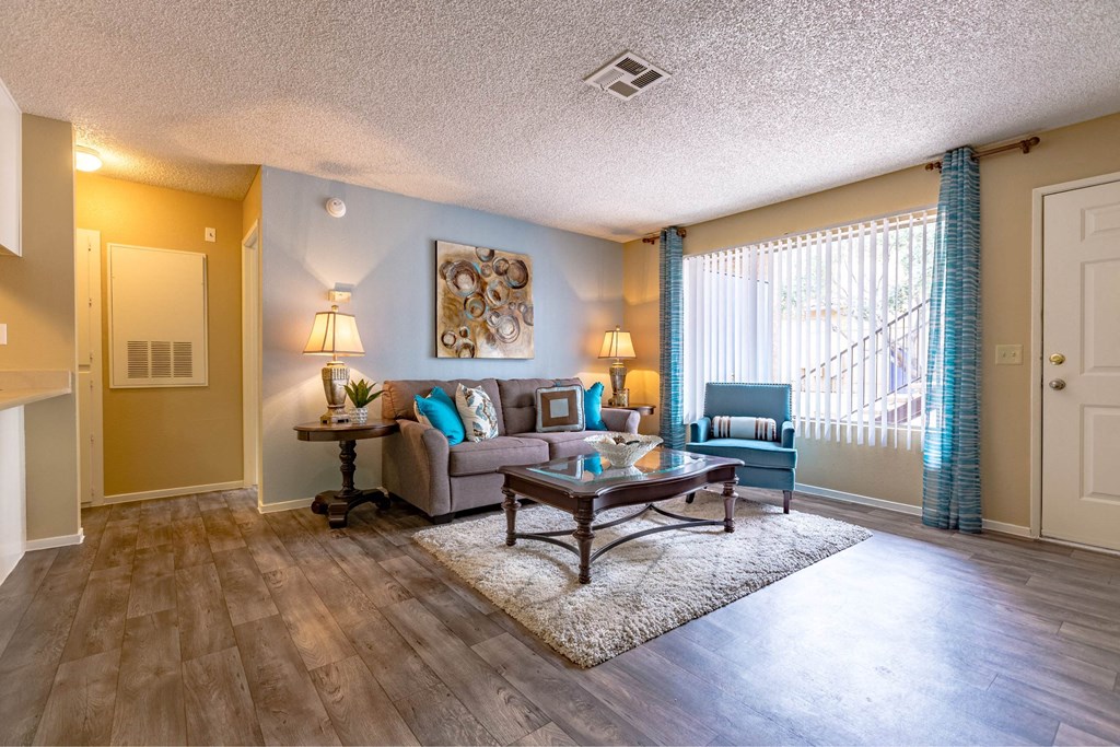 A living room with a couch, a table, and a painting on the wall.