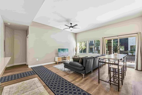 A living room with a grey couch and a black and white rug.