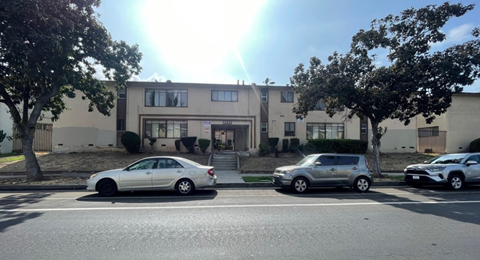 A silver car is parked on the left side of the street.
