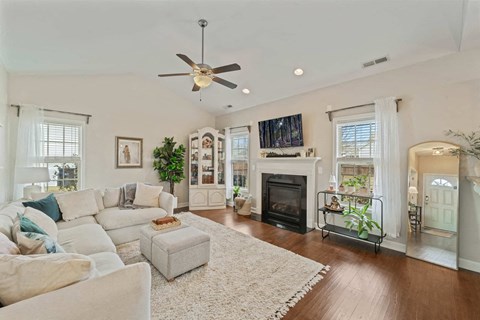 A living room with a white couch and a fireplace.