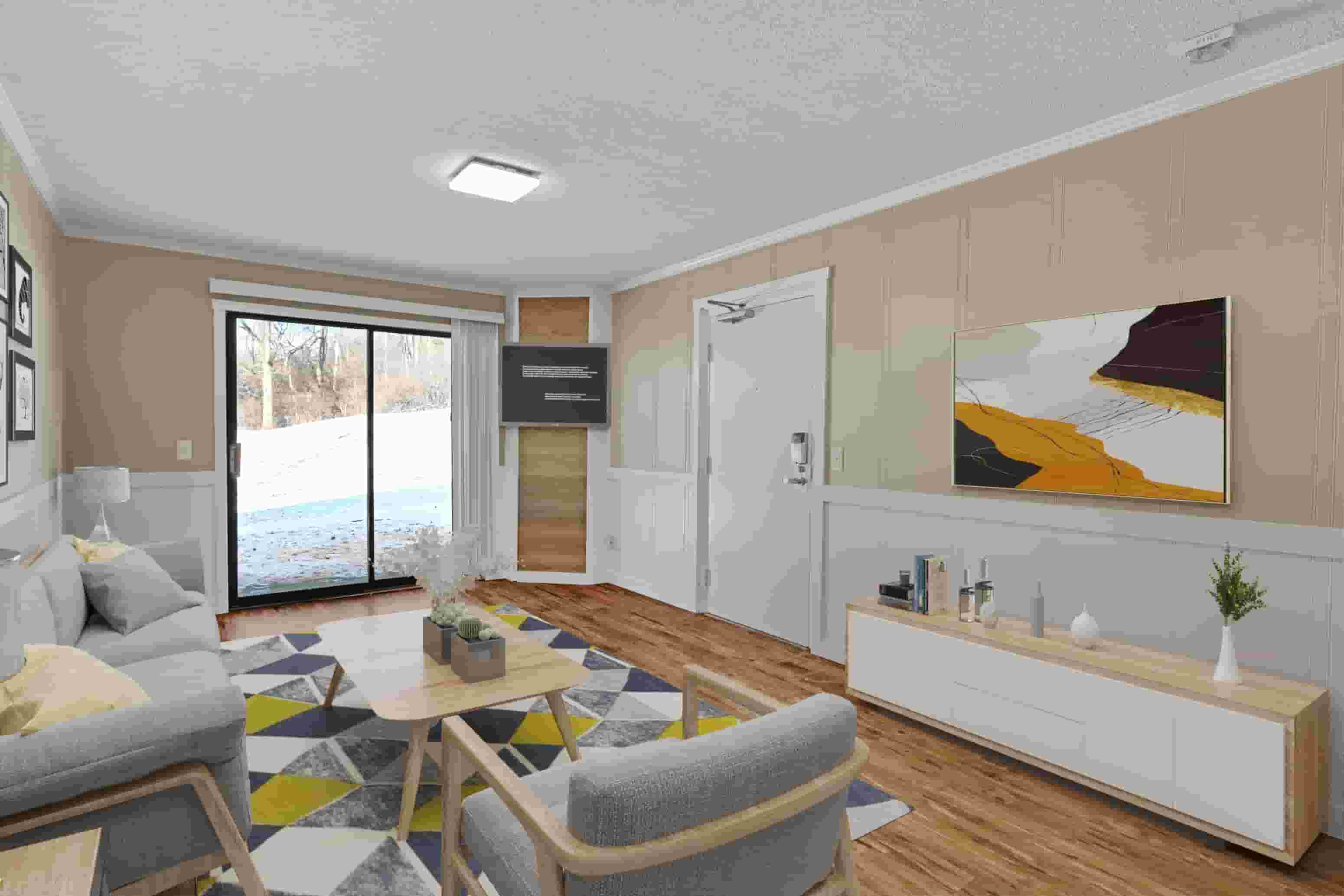 A living room with a grey couch, a coffee table, and a painting on the wall.