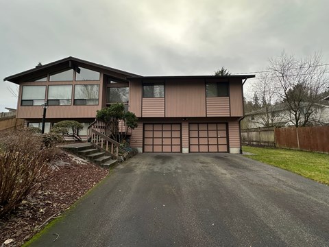 A house with a brown garage door and a driveway in front.