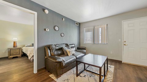 A living room with a brown leather couch and a wooden coffee table.