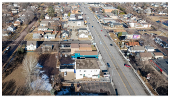 A road with cars and houses on the side.