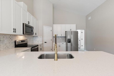 A kitchen with a sink and a refrigerator.
