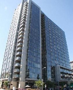 A tall building with many windows and balconies is shown.