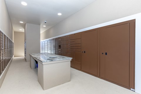 A room with a counter and brown cupboards.