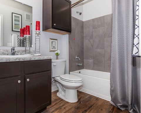 A bathroom with a white toilet and a grey shower curtain.