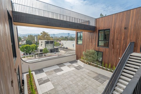 A modern house with a wooden exterior and a glass balcony.