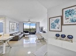 A modern living room with a white couch and a large window.