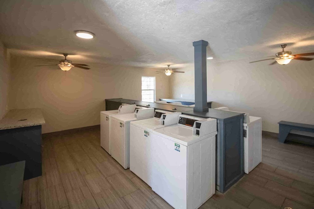 A room with a white washer and dryer set up next to each other.