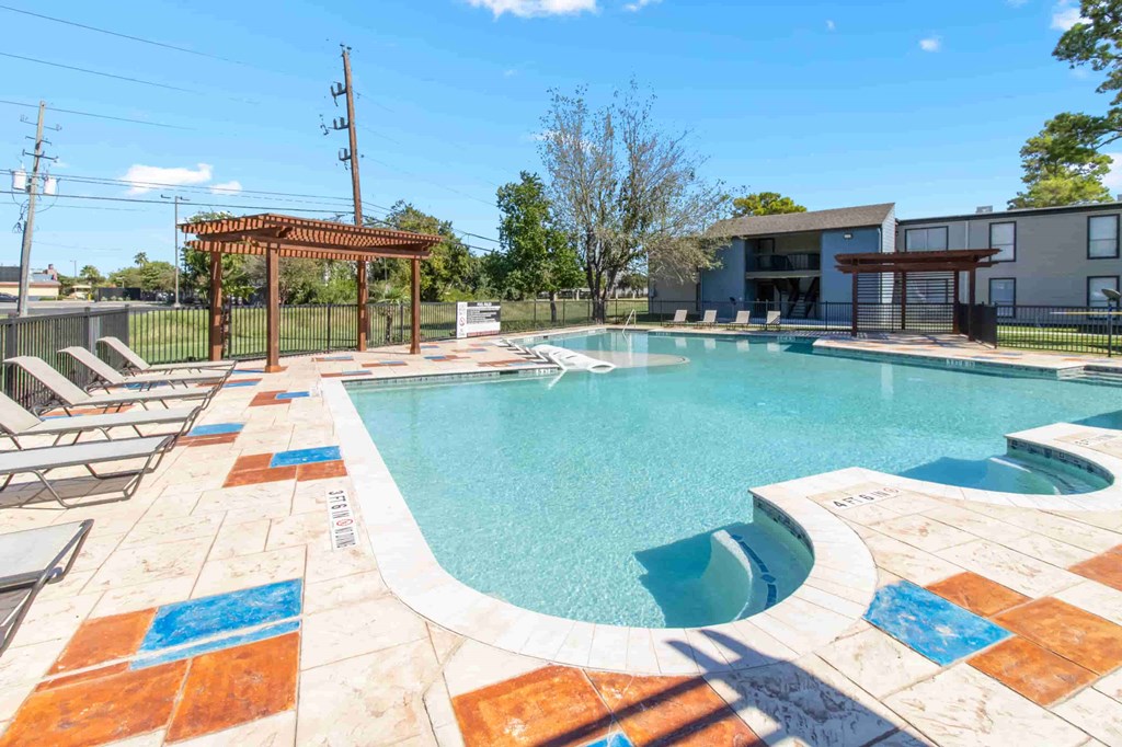 A pool with a brown pergola and a blue tile border.